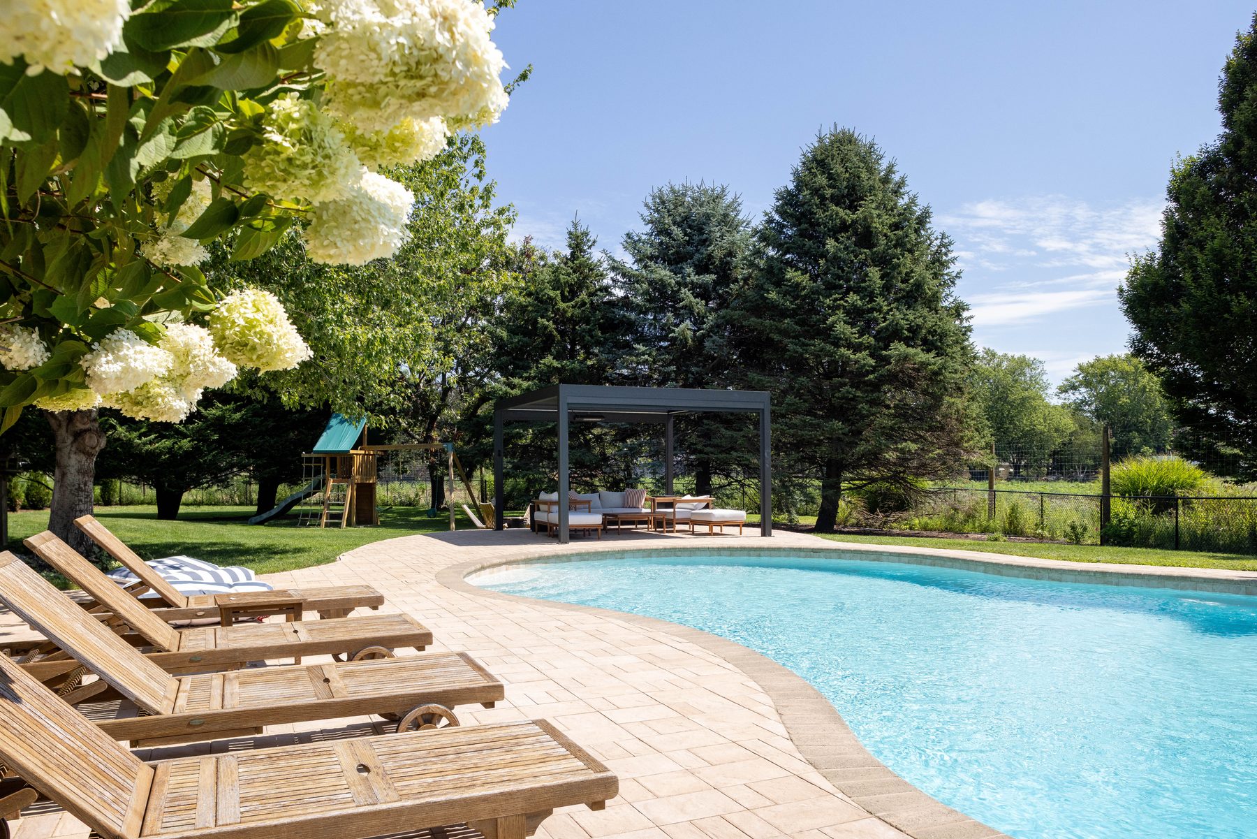 Heated saltwater pool surrounded by manicured lawn at The Cove NoFo in Greenport, NY